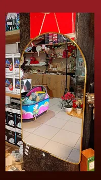 مرآة حائطية بإطار ذهبي مقوس