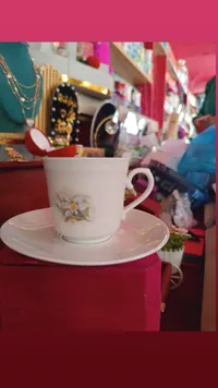 فنجان قهوة مع صحن مزين برسمة زهرة