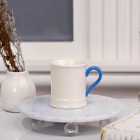 كوب سيراميك أبيض بمقبض أزرق