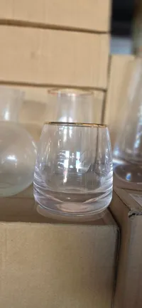 كأس زجاجي شفاف بحافة ذهبية
