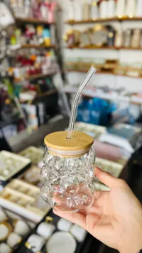 كوب زجاجي مع غطاء خشبي وماصة