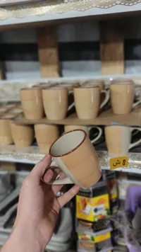 مج زجاج بيج مع حافة حمراء