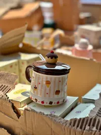 كوب بغطاء وملعقة بتصميم حلويات