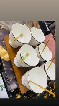طقم أوعية سيراميك بيضاء مع ملاعق ذهبية