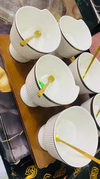 أوعية سيراميك بيضاء مع ملاعق ذهبية