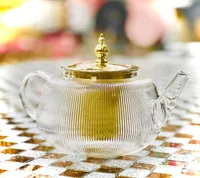 إبريق شاي زجاجي مع غطاء ذهبي