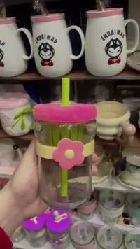 كوب زجاجي بغطاء وقشة وتصميم الزهرة