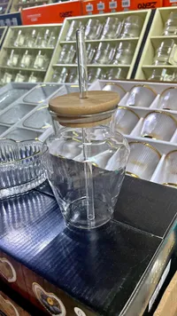 كوب زجاجي مع غطاء خشبي وقشة