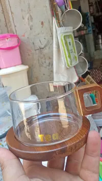 كوب شاي زجاجي مع قاعدة خشبية