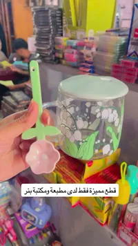 كوب زجاجي مزين بالزهور مع ملعقة