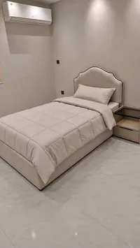 سرير مفرد بتصميم عصري مع طاولة جانبية