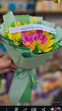باقة زهور ملونة مع شريط تهنئة
