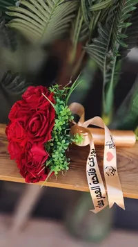 باقة ورد أحمر للعروس مع شريط إهداء