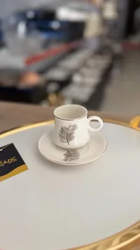 فنجان قهوة مع صحن - تصميم أوراق الشاي