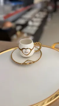 فنجان قهوة عربي بتصميم ذهبي وأبيض