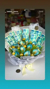 باقة هدايا فاخرة - أوراق نقدية وكرات زينة ذهبية وزرقاء