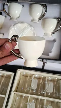 فنجان قهوة سيراميك أبيض بمقبض معدني