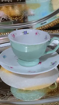 فنجان شاي مع صحن بنقوش زهرية
