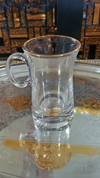 كوب زجاجي شفاف بحافة ذهبية
