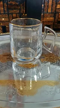 كوب زجاجي شفاف بحافة ذهبية