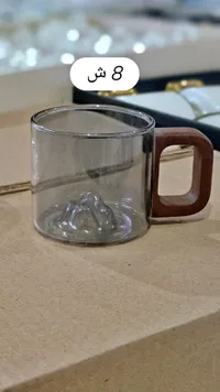 كوب زجاجي بتصميم جبلي ومقبض خشبي