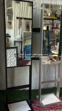 ستاند من يوم باللون الأسود و السلفر رفوف زجاج من الخلف للميك اب