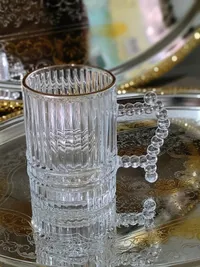 كوب زجاجي بمقبض مزخرف