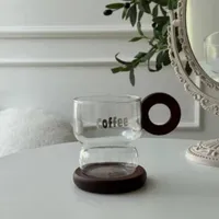كوب زجاجي بتصميم عصري مع قاعدة ومقبض خشبي