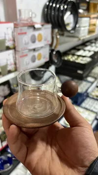 كوب شاي زجاجي مع قاعدة خشبية