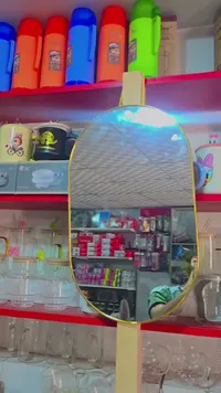 مرآة بيضاوية بإطار ذهبي وقاعدة خشبية