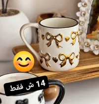 مج سيراميك بتصميم فيونكات ذهبية - سوق غزة