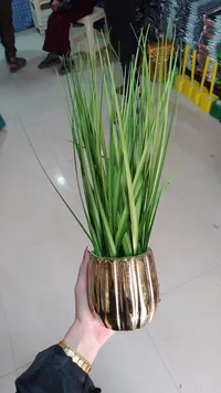 نبات صناعي مع إناء ذهبي
