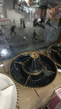 مضيفة زجاج سوداء مع إطار ذهبي