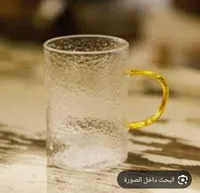 كوب زجاجي بنقش محفور مع مقبض ذهبي