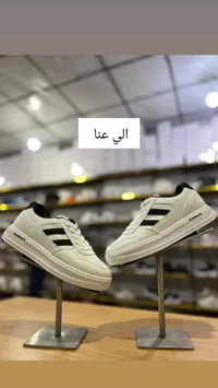 حذاء رياضي أبيض بخطوط سوداء