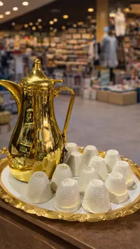 فناجين قهوة عربية بيضاء مع إبريق ذهبي